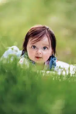 bébé sur le ventre dans un champ