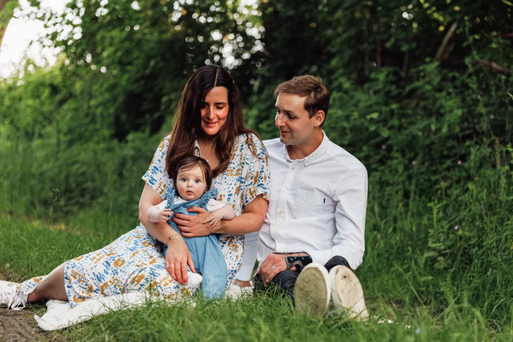 couple avec bébé assis dans un pré