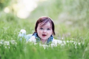 un bébé sur le ventre dans l'herbe