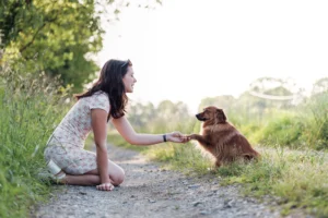une maitresse et son chien se tenant par la patte