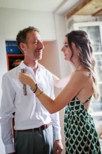 une fille fait le noeud papillon de son père